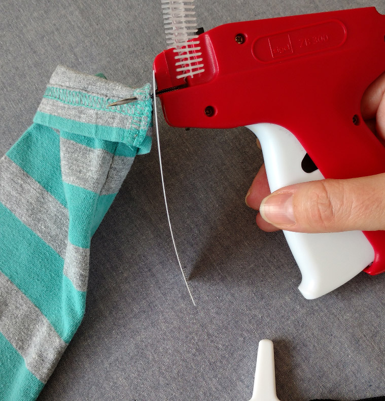 Tagging gun with needle inserted into fabric tagging gun needle